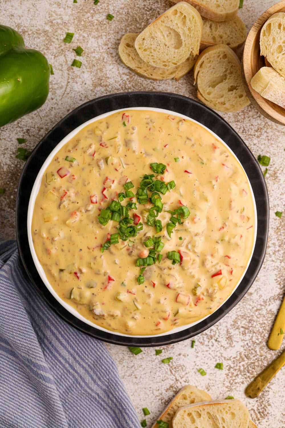 Crock Pot Philly Cheesesteak Dip in a bowl with some green garnish on top
