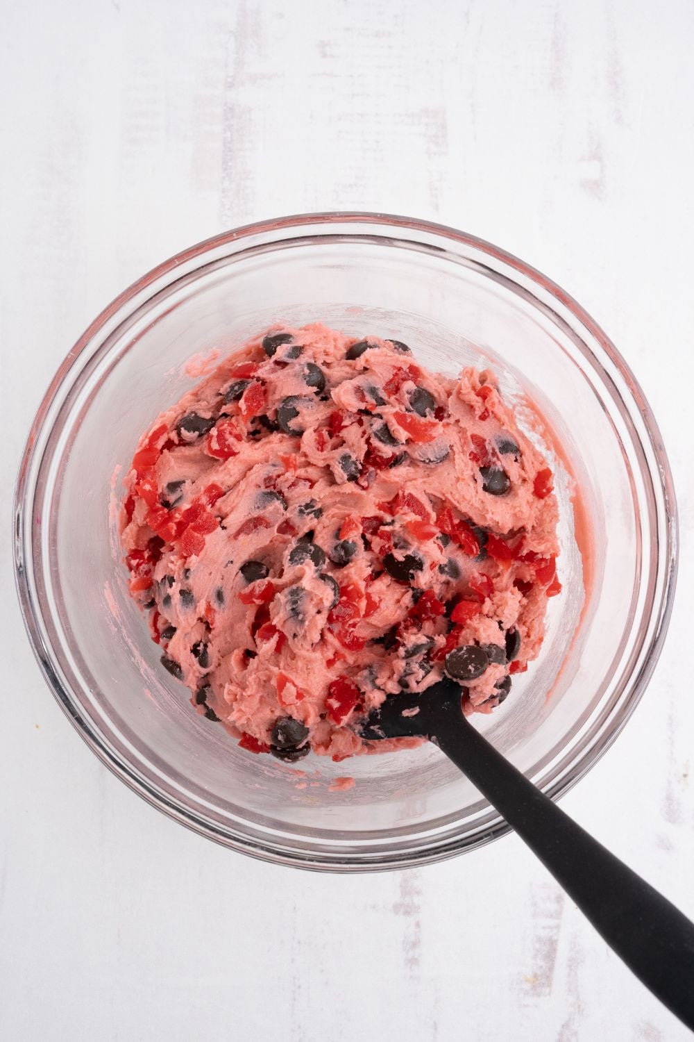 Cherry Chocolate Chip Cookie dough in a bowl with a spoon on the side 