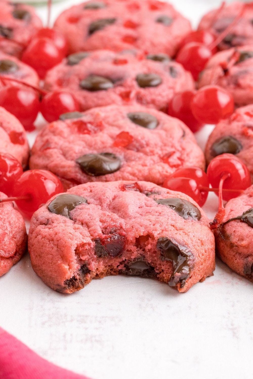 Cherry Chocolate Chip Cookies placed on the table and a bite taken out of one of the cookies 