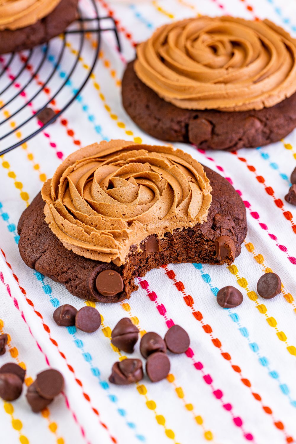 Chocolate Cake Cookie on table with a bite taken out of it and mini chocolate chips scattered around the cookie 