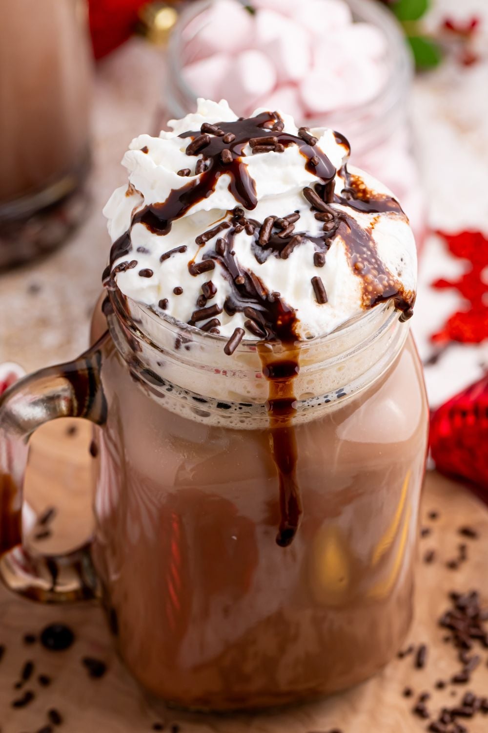 chocolate syrup poured over a chocolate milkshake with sprinkles on top