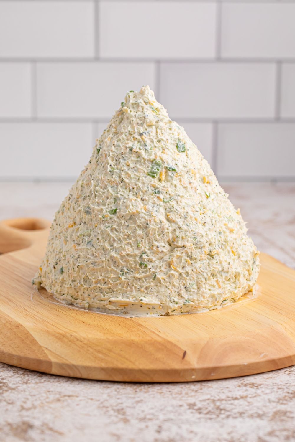 dome shaped cheeseball on wooden cutting board