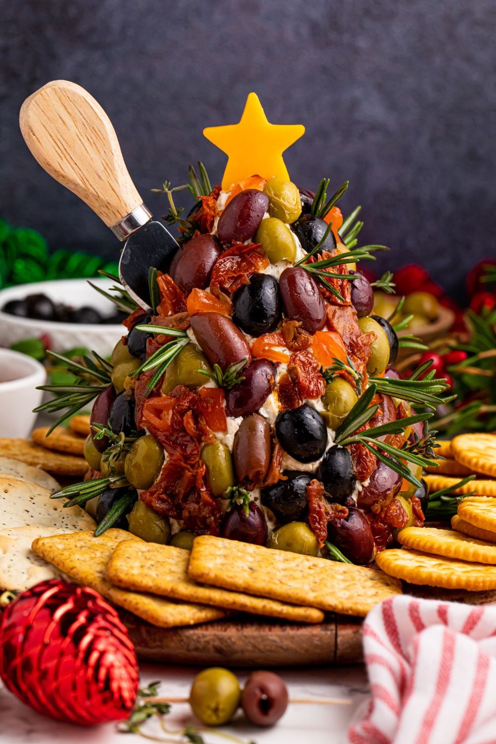 Antipasto Christmas Tree Cheeseball with a knife stuck in side of it