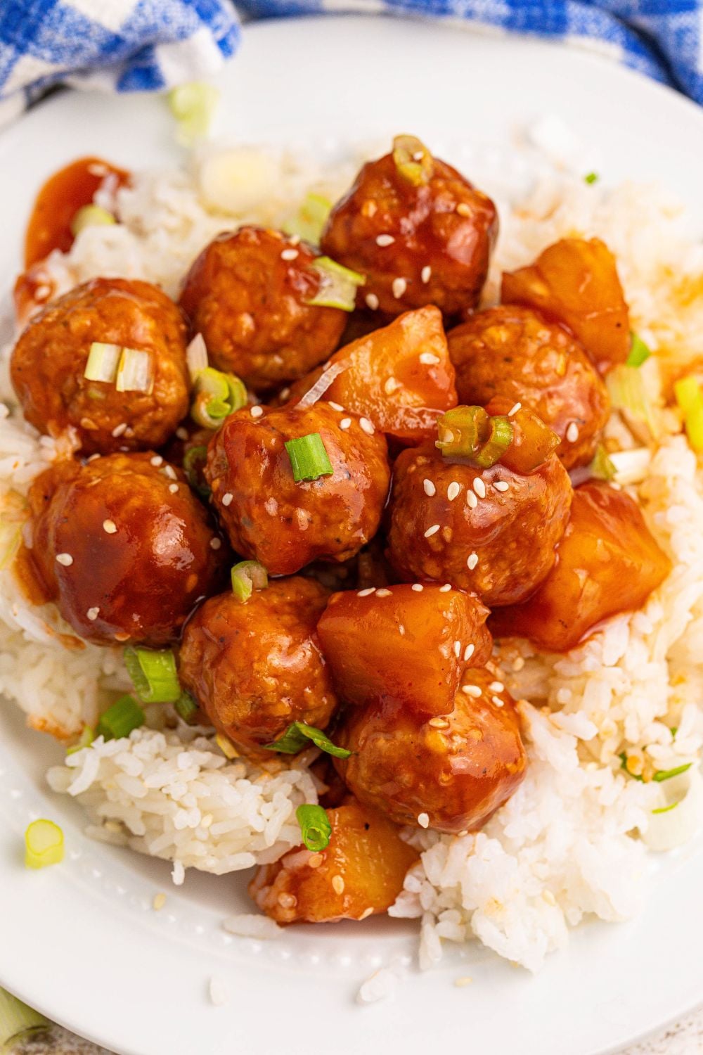 Slow Cooker 3 Ingredient Hawaiian Meatballs on plate with a bit of white rice under the meatballs 