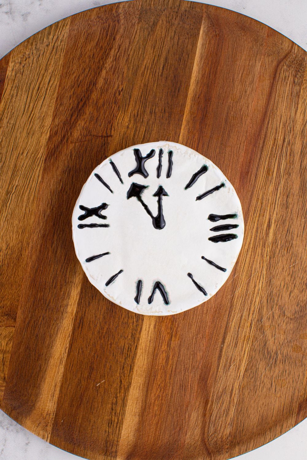 New Year's Eve Charcuterie Board being started to assemble. The brie cheese with clock drawn on 