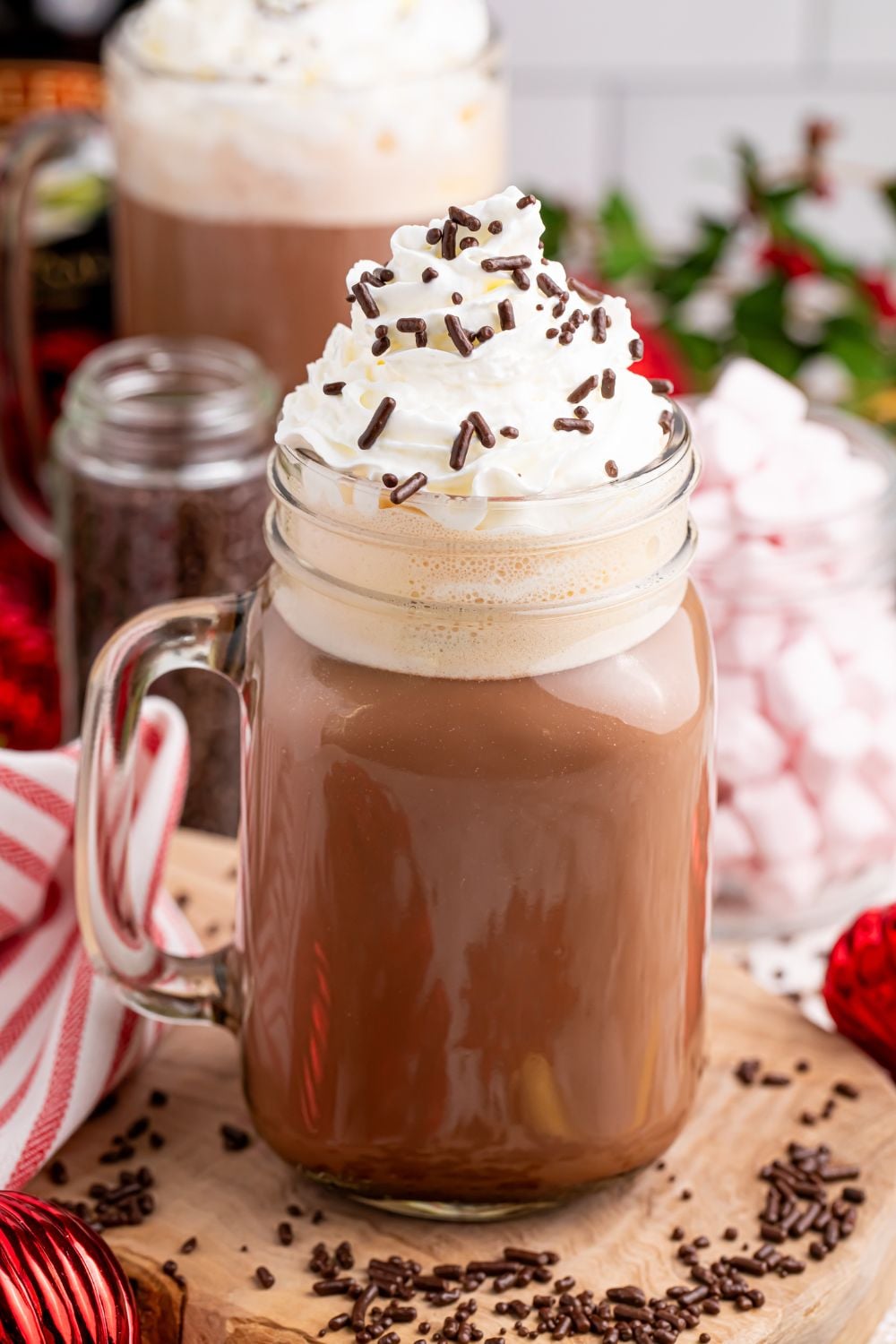 a drunken hot chocolate drink on table with whipped cream and sprinkles on top