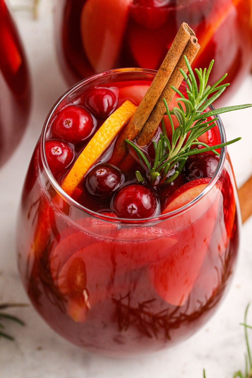 glasses of wine cocktails in it with cranberries and an orange slice in glasses