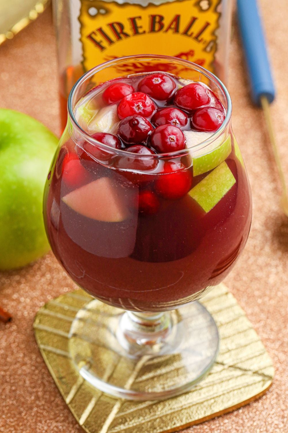 Fireball Sangria in glass with apple behind it
