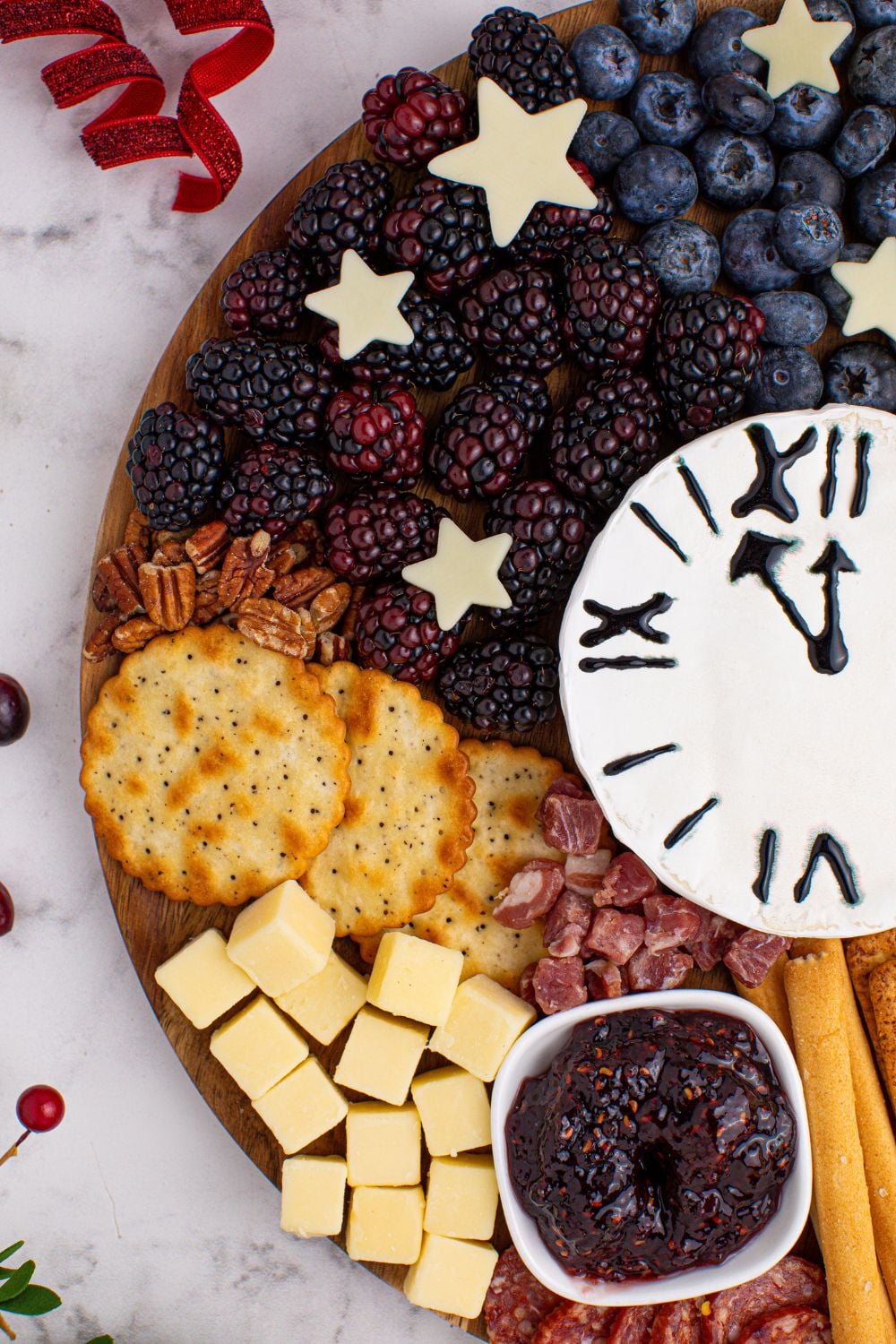 side view of the New Year's Eve Charcuterie Board on a table with some food sprinkled around it on table 