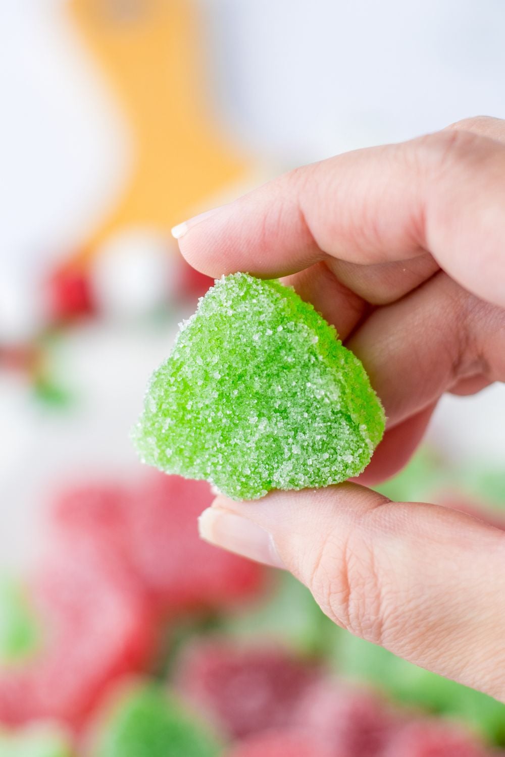 holding a green gummy 