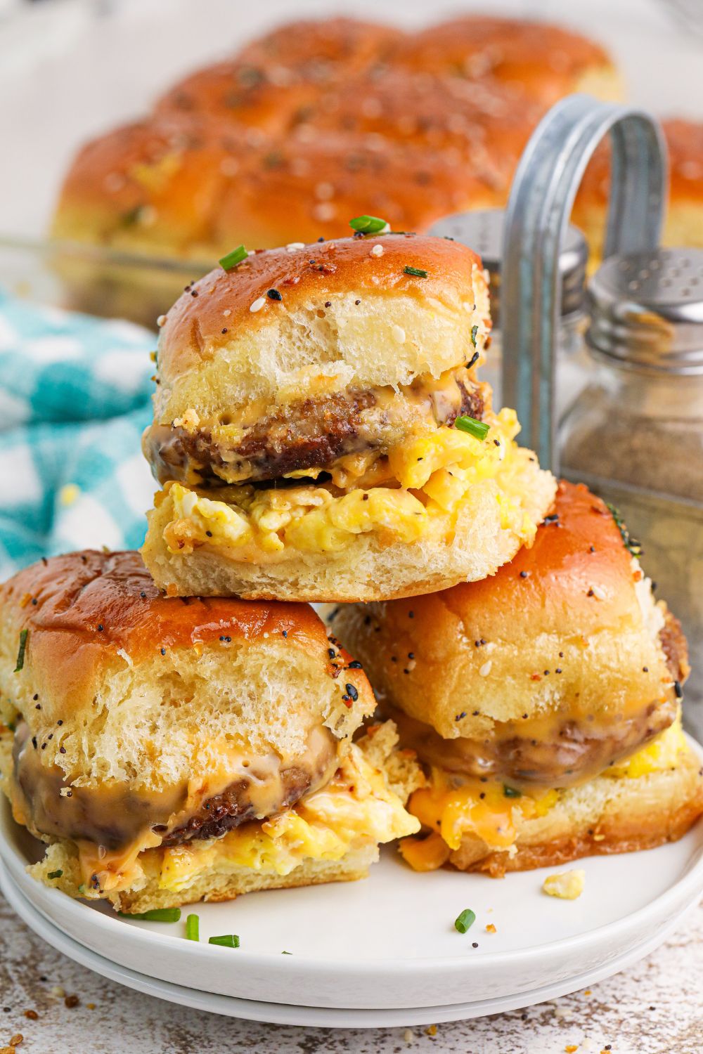Breakfast Sliders on a plate with a close up so you can see the fillin in each sandwich