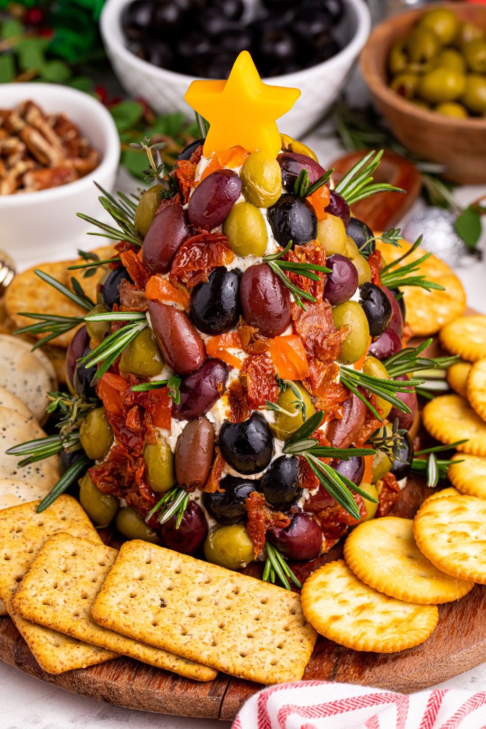 holiday cheeseball on platter with crackers and nuts around it