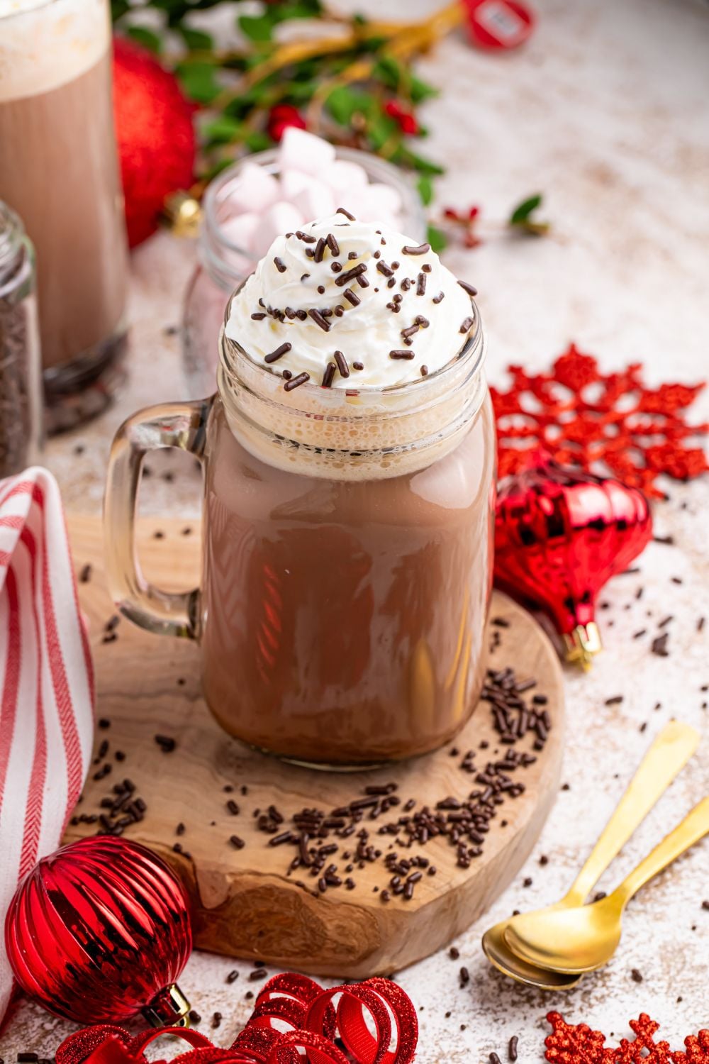 Dirty Snowman on the table on a coaster with Christmas decorations around the glass and sprinkles around the glass