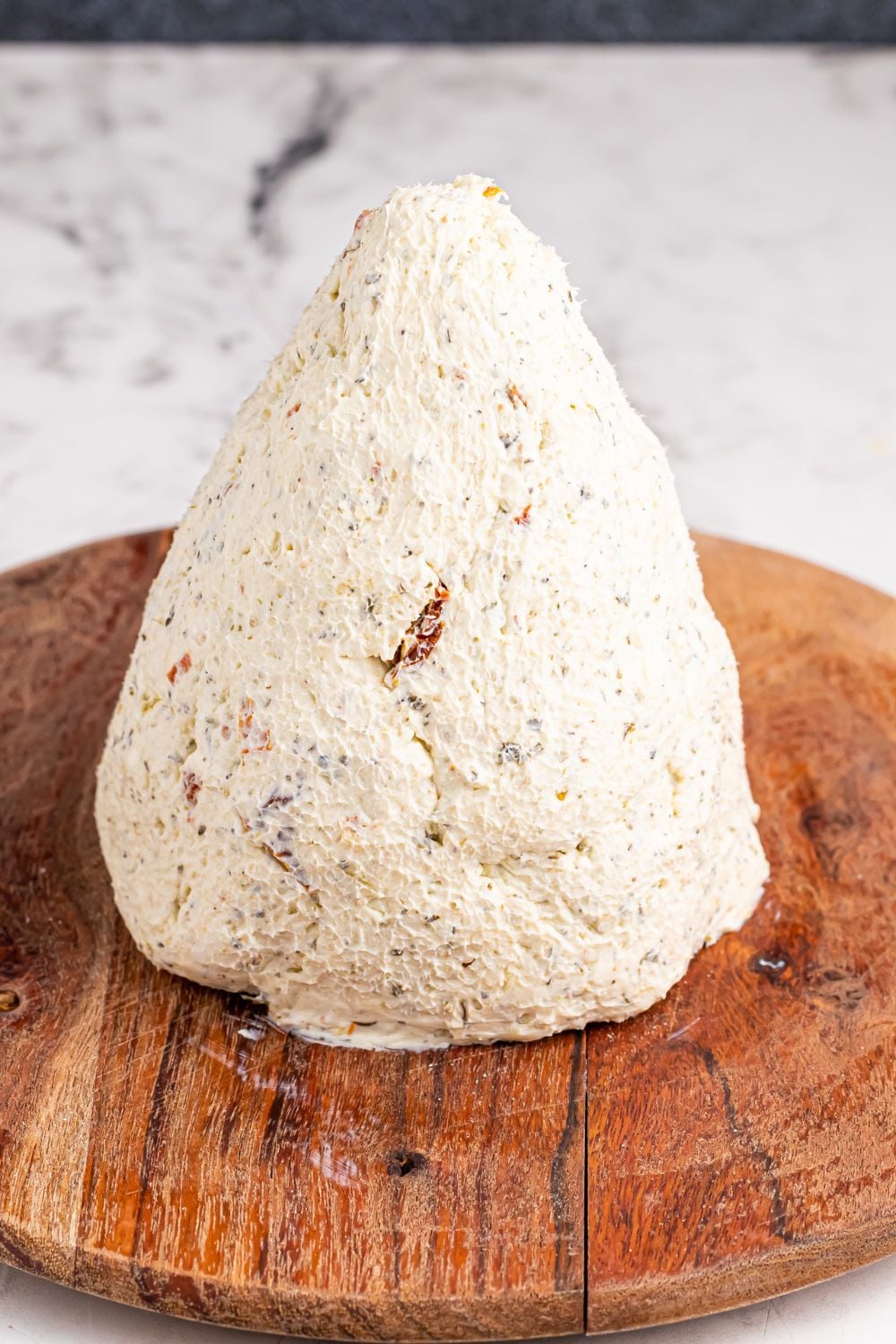 cone shaped cheeseball on round cutting board