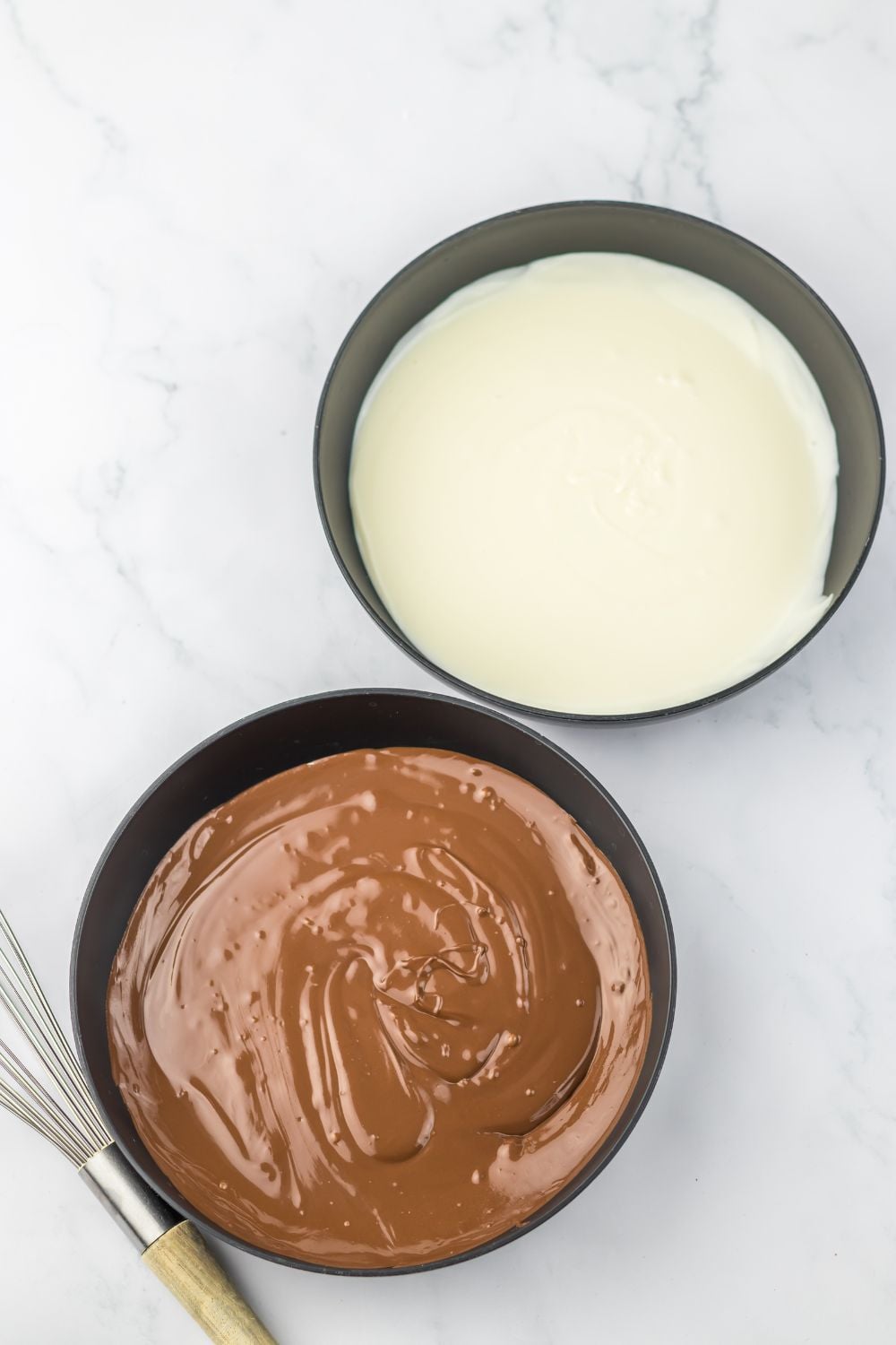 white chocolate and milk chocolate melted in bowls on table