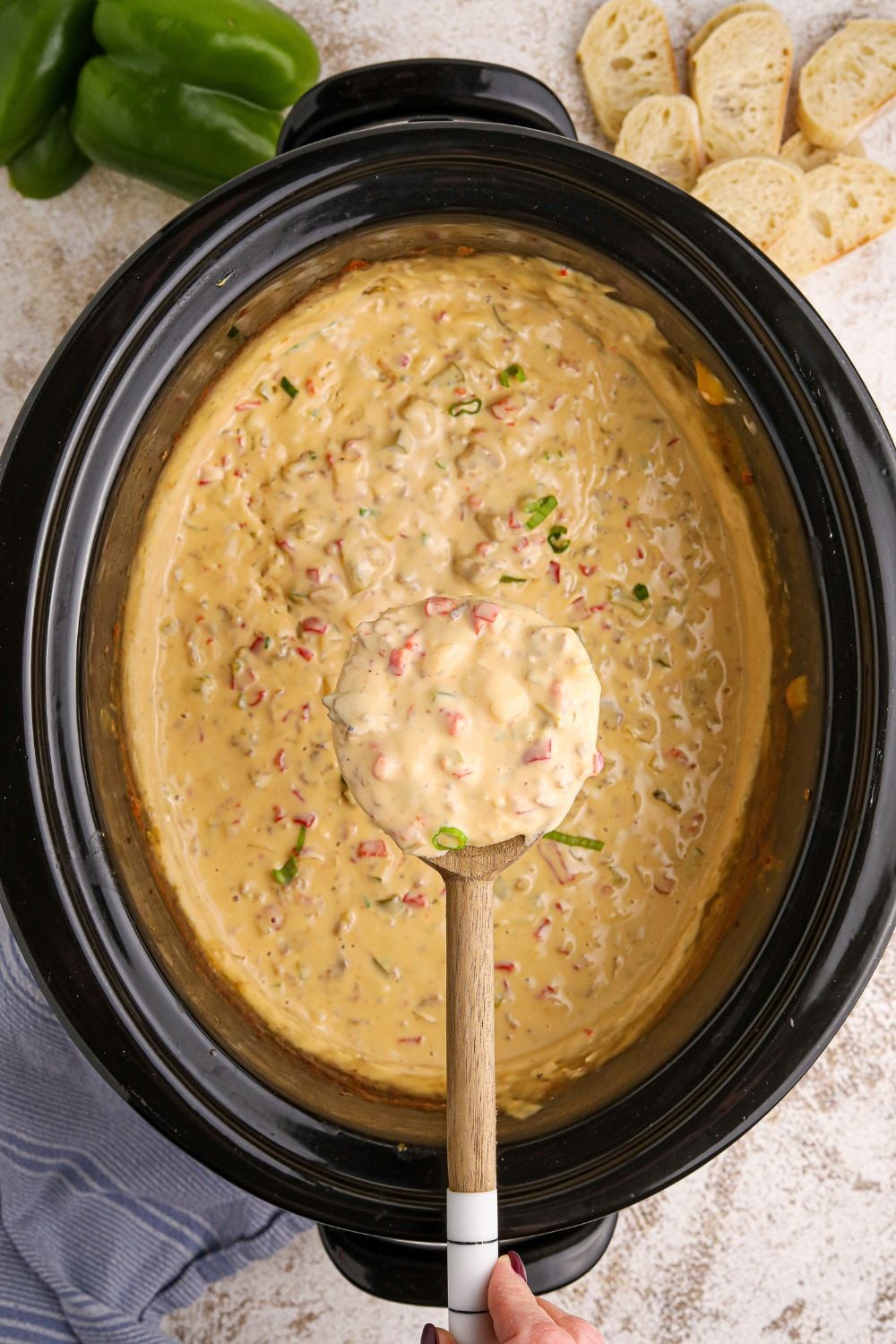 Crock Pot Philly Cheesesteak Dip in a slow cooker with a spoon full of dip over the crockpot