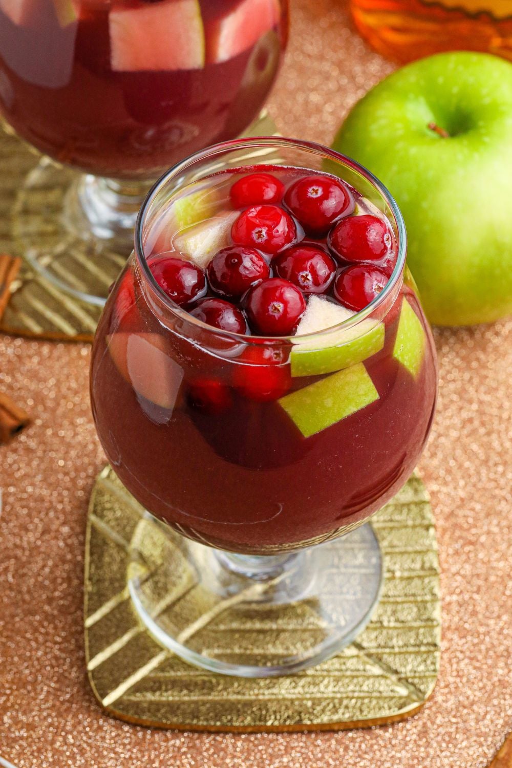 cocktail on a coaster with apple in the background
