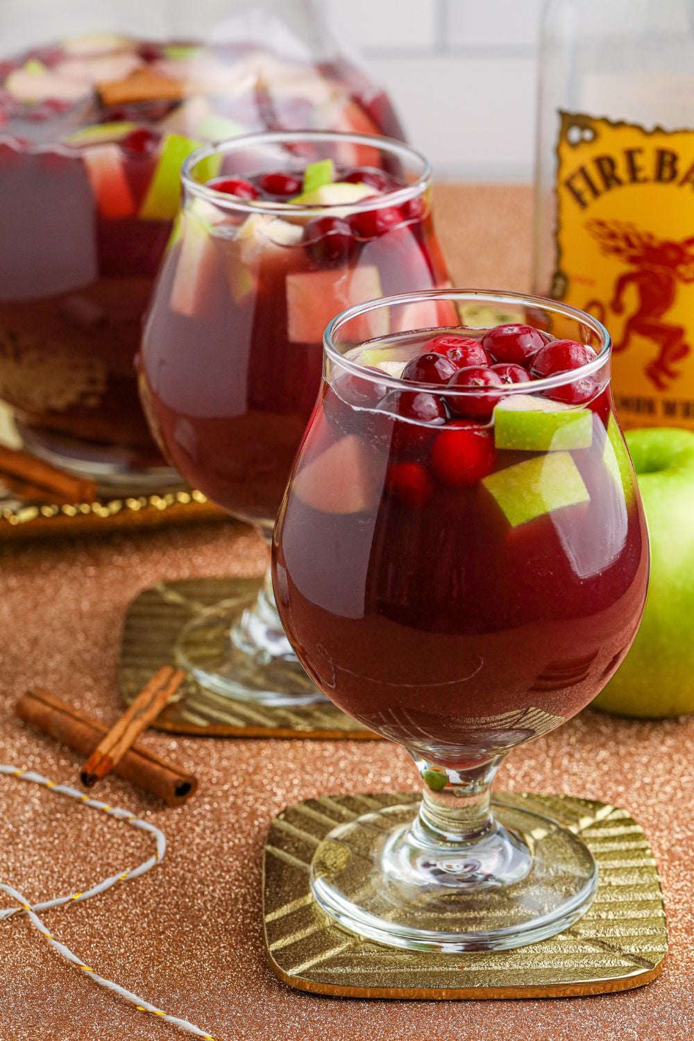 sangria with fireball, apples and cranberries in glass