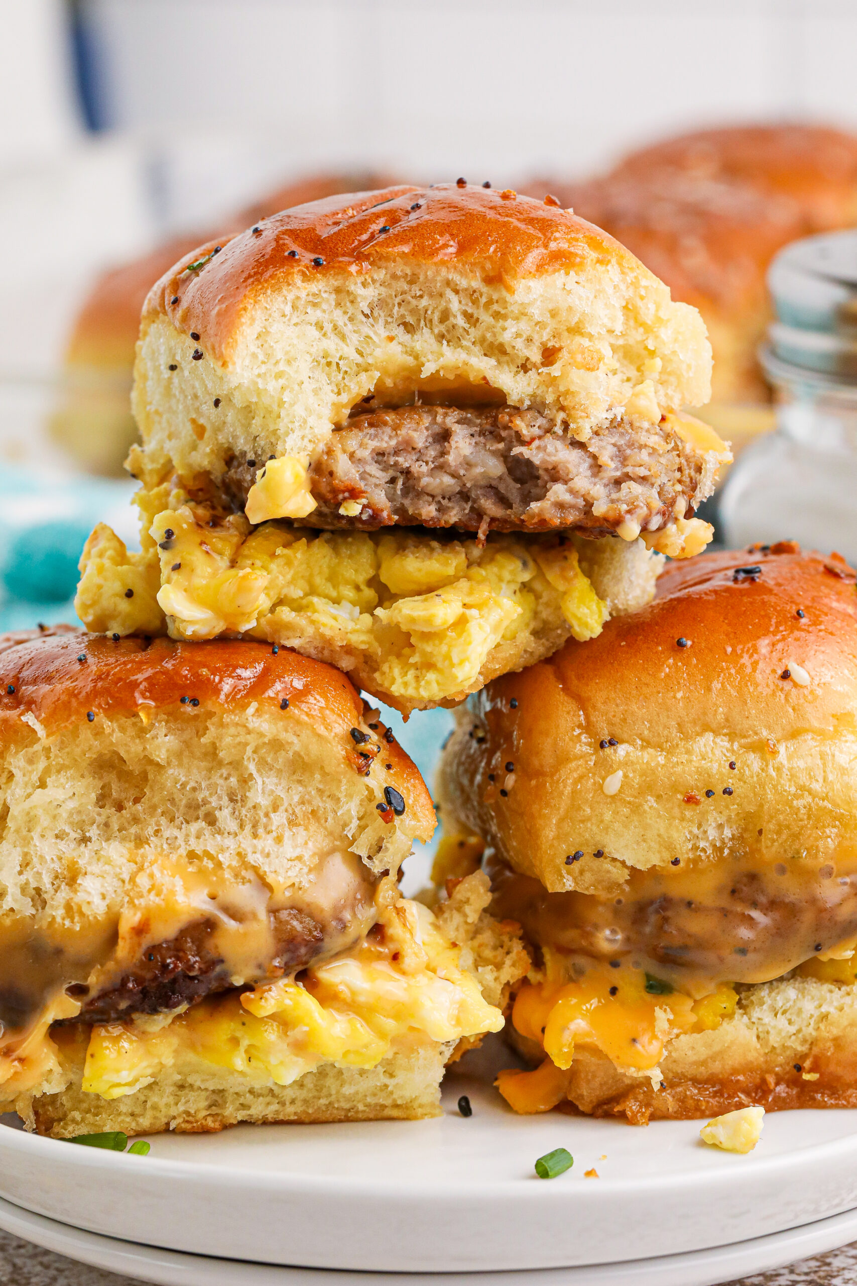Breakfast Sliders with Sausage cheese and eggs on a white plate stacked