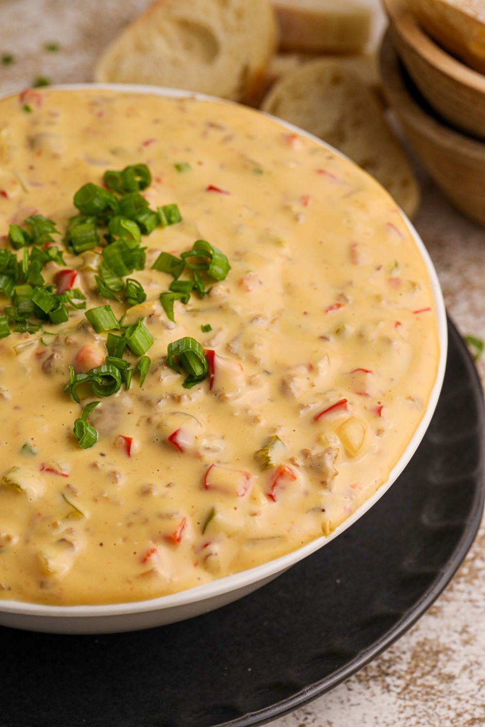 Crock Pot Philly Cheesesteak Dip in a white bowl on table with garnish on top