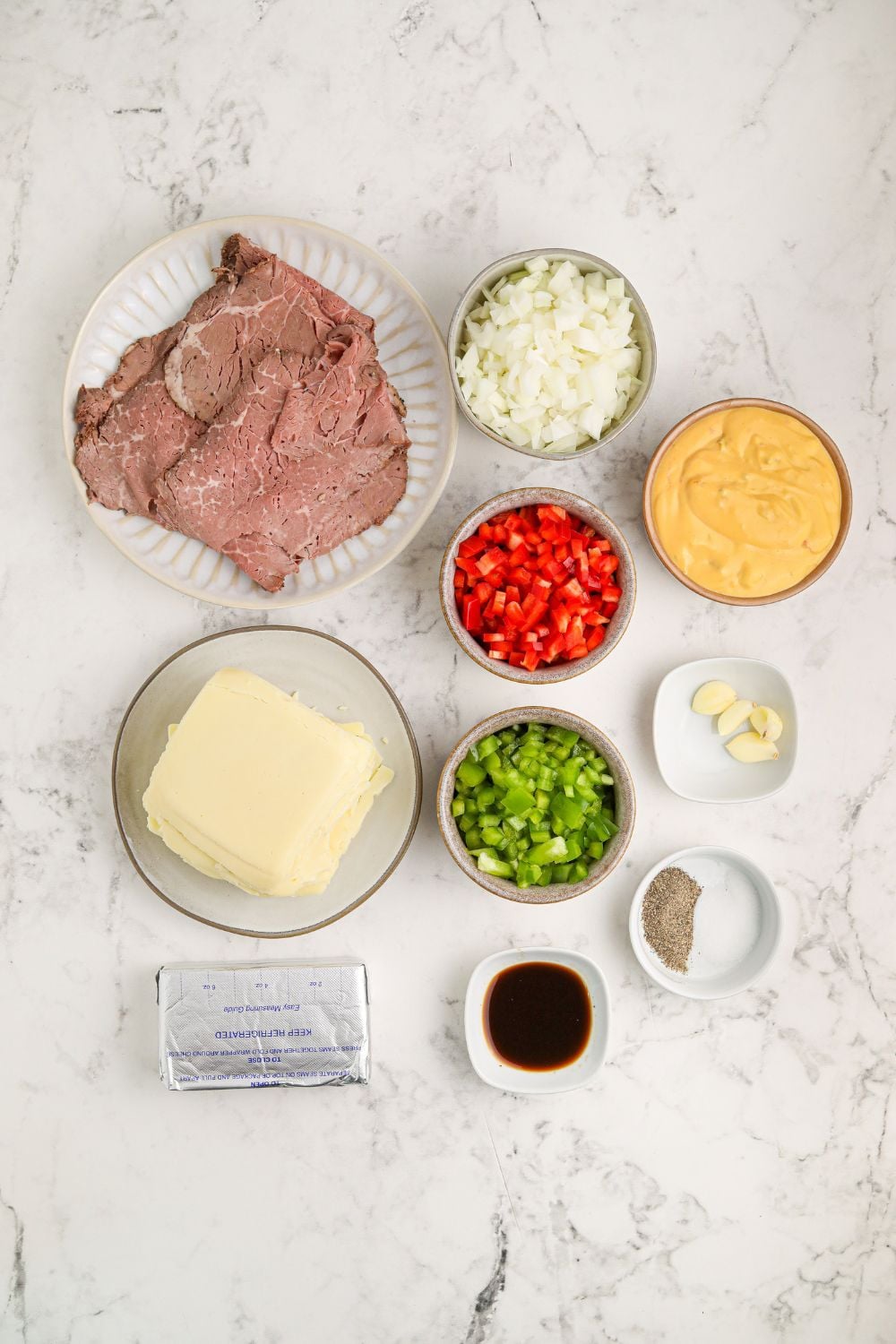 Crock Pot Philly Cheesesteak Dip ingredients on the table in small glass bowls to show all items used