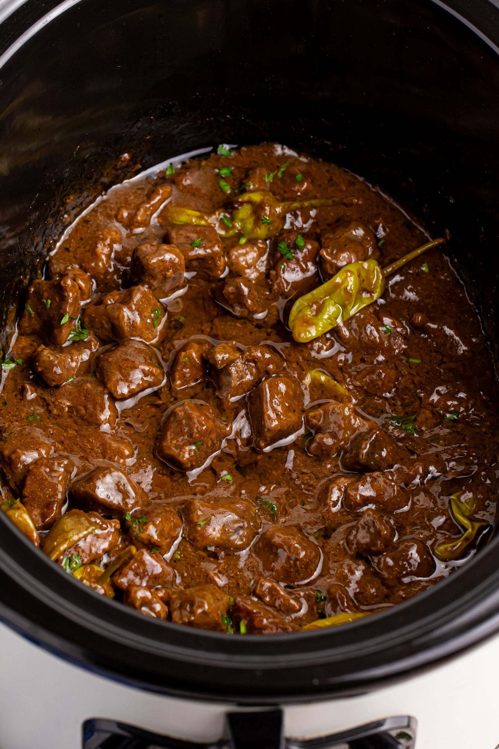 Crockpot Mississippi Steak Bites overhead view of crockpot with parsley garnished on top