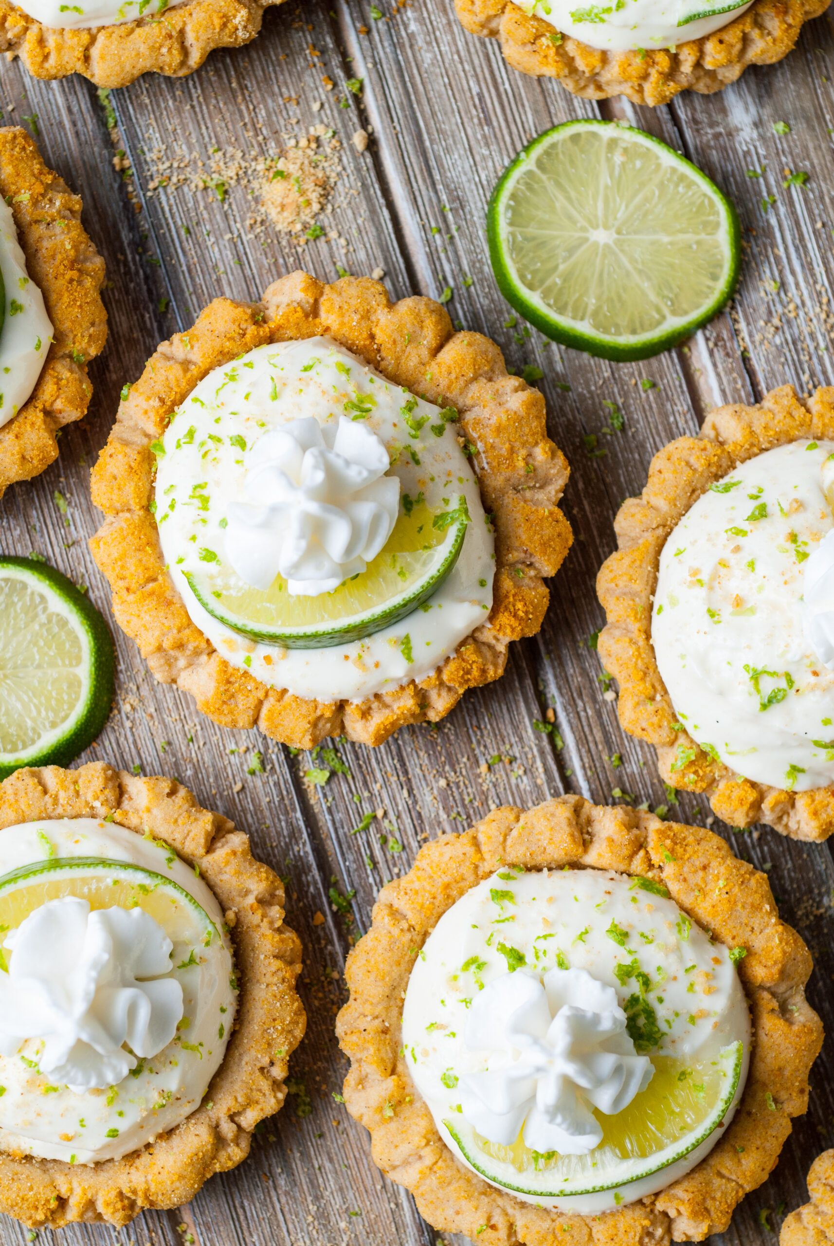 overhead shot of the Crumbl Key Lime Pie Cookies on table with lime wedges