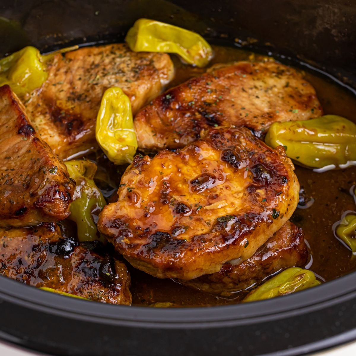 Crock Pot Mississippi Pork Chops in a crock pot with peppers on top of pork chops