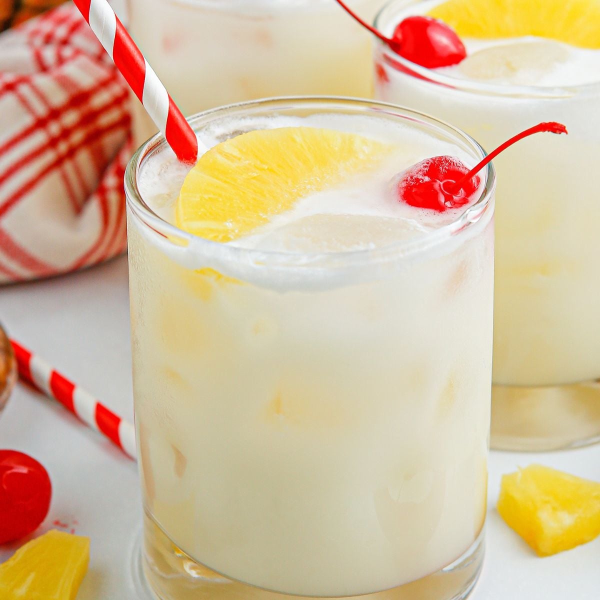 Pina Colada Punch in glasses with red and white straws in each glass