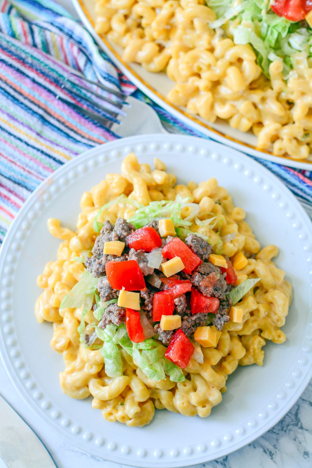 Big Mac Macaroni And Cheese on a plate with a pan of it behind it