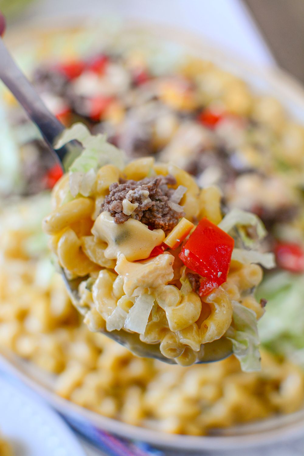 Big Mac Macaroni And Cheese in a spoon above the platter