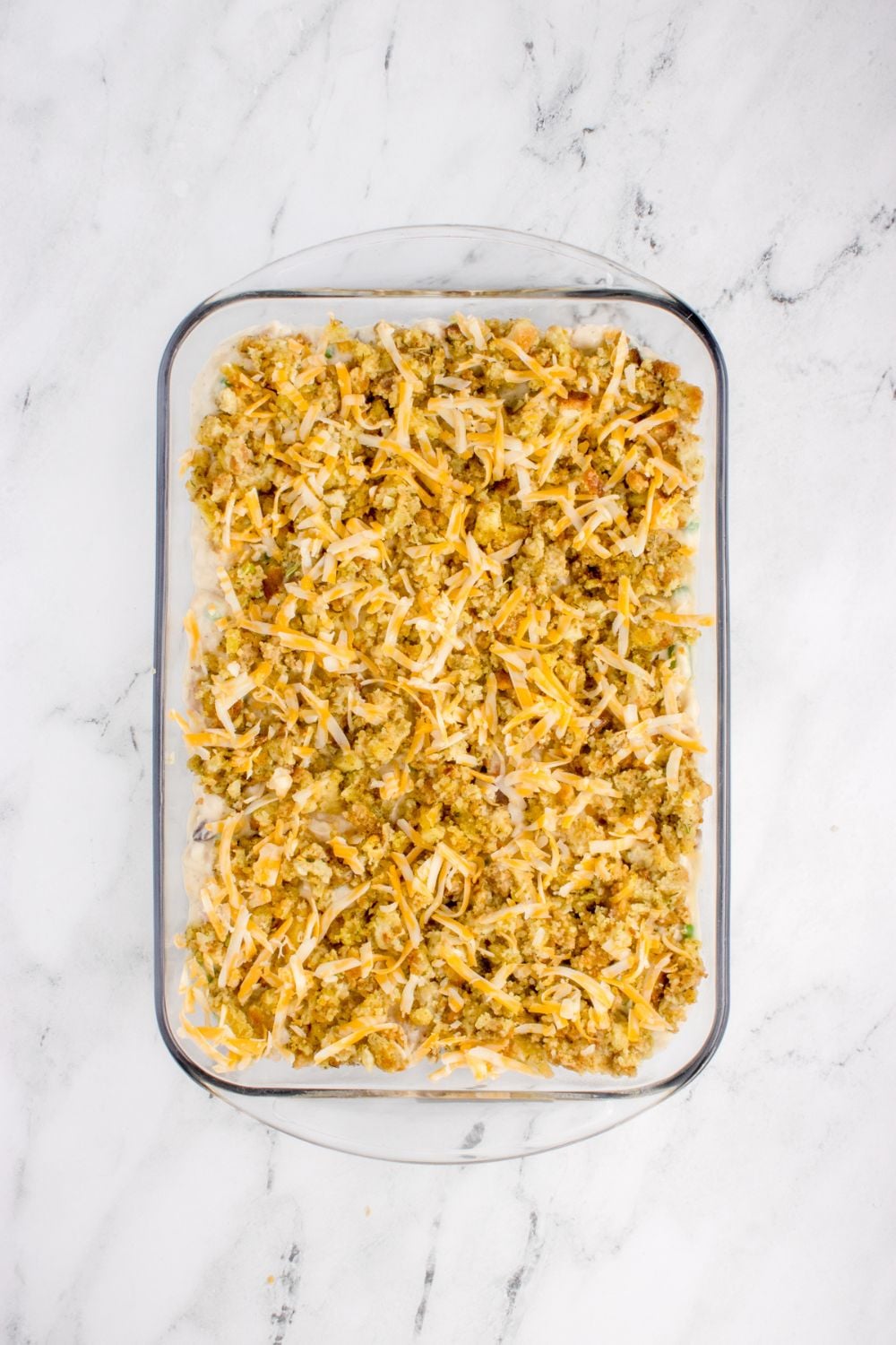 Chicken Stuffing Casserole overhead look with cheese on top of stuffin mix in the casserole pan