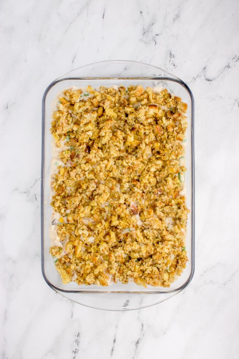 Chicken Stuffing Casserole in a pan unbaked on a marble counter