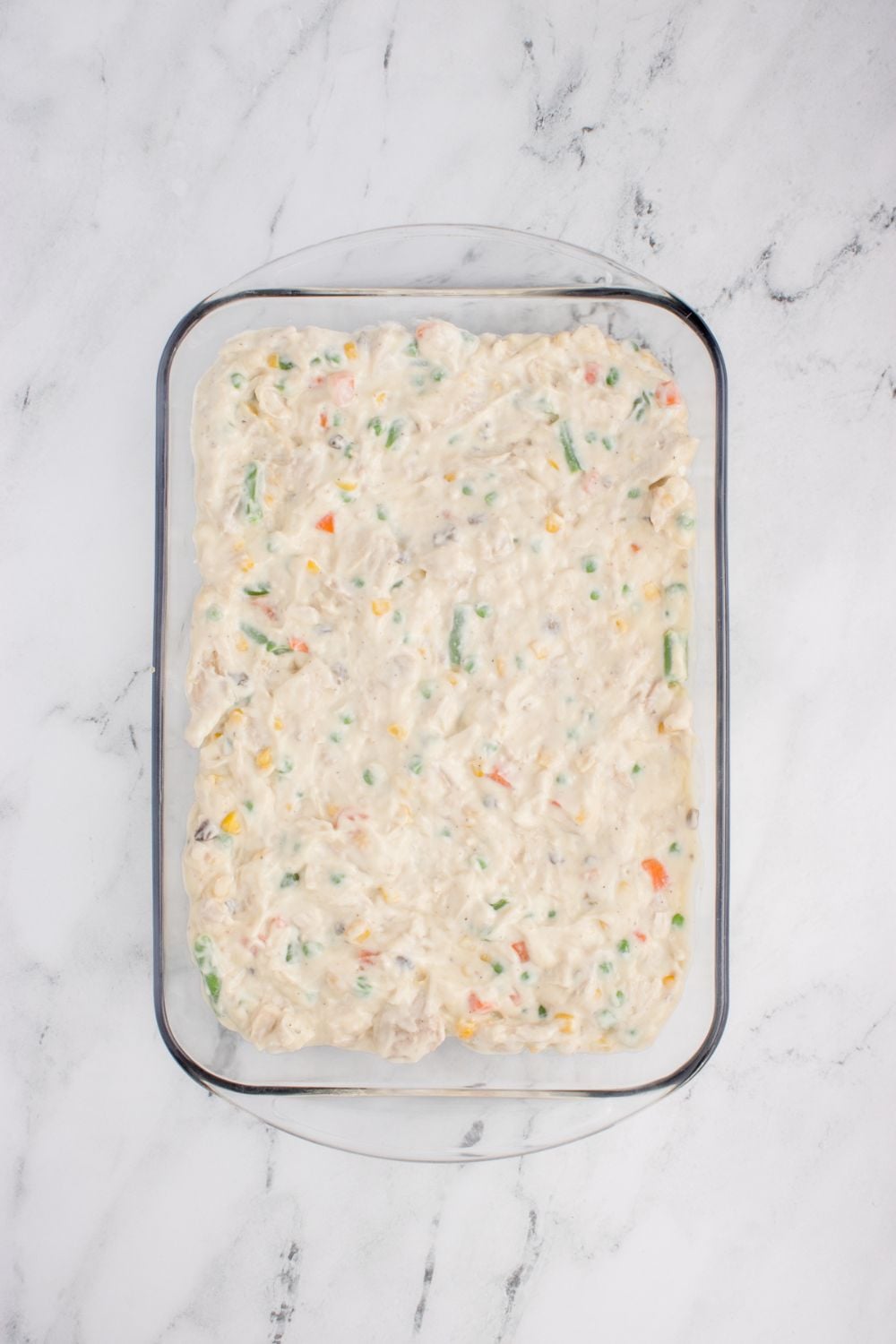 wet Chicken Stuffing Casserole mixture spread evenly in a glass casserole dish