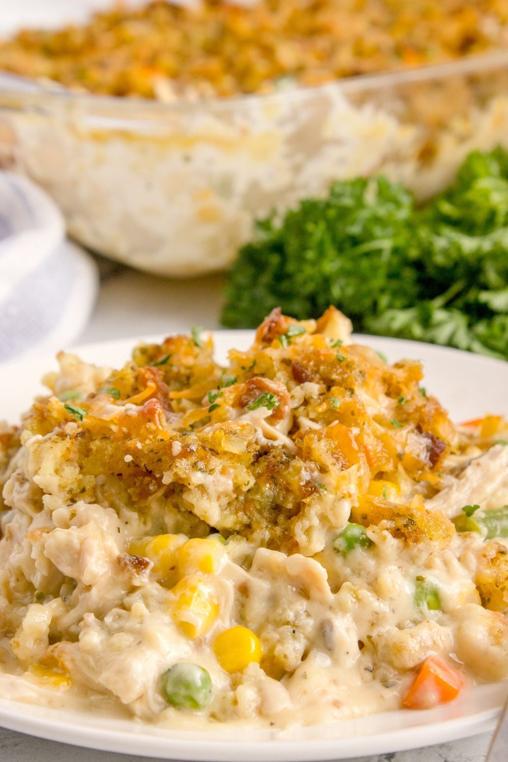 Chicken Stuffing Casserole on plate with a casserole dish in the background