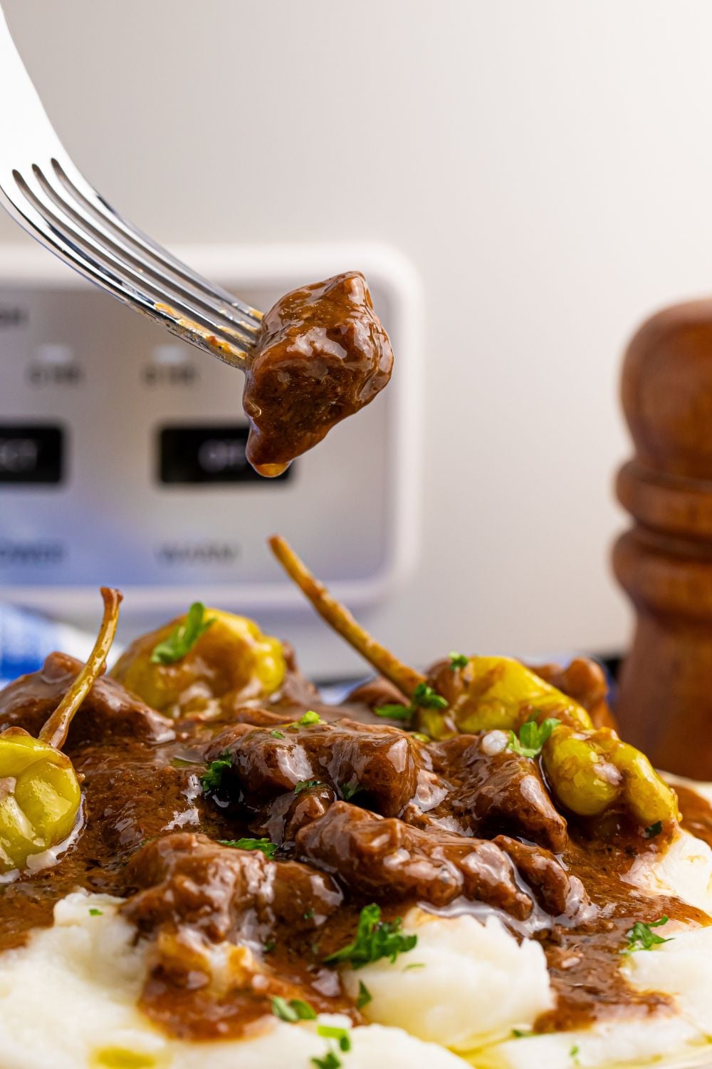 Crockpot Mississippi Steak Bites on plate with a fork with piece of steak on fork above plate