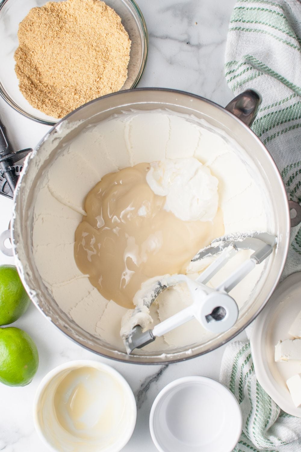 Crumbl Key Lime Pie Cookie filling in a mixer bowl with condensed milk poured in the center of bowl