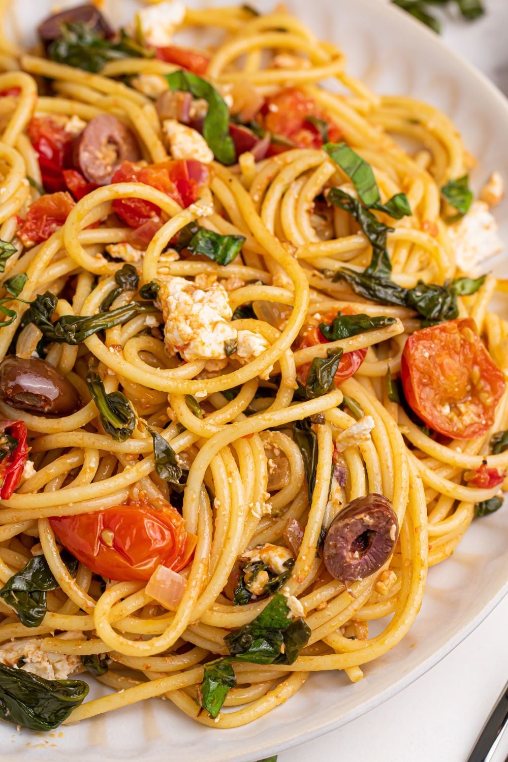 Greek Spaghetti on a plate with a side view of plate to showcase all the ingredients in dish 