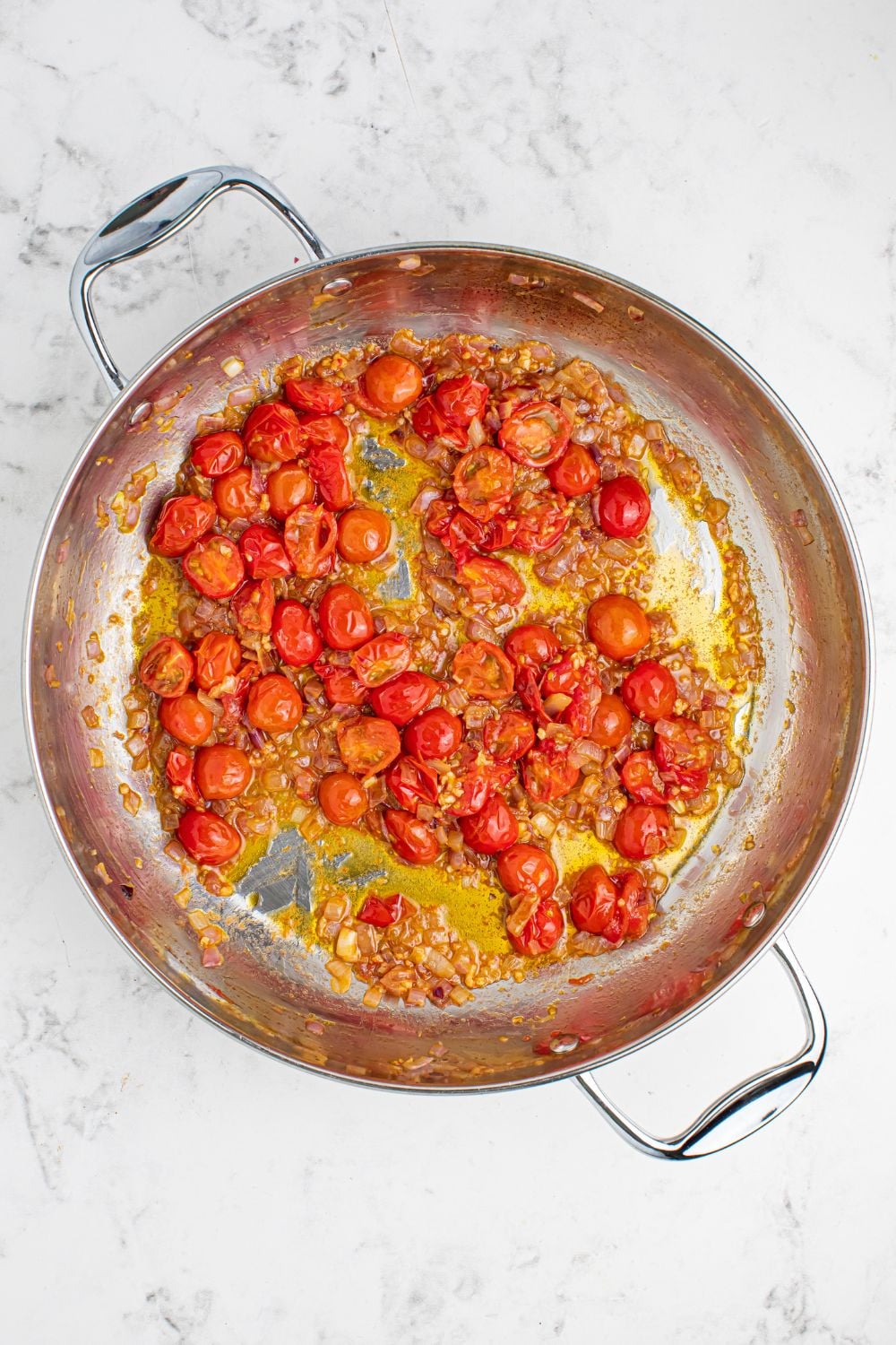 Greek Spaghetti roasted tomatoes in a pan on table with a little oil in it. 