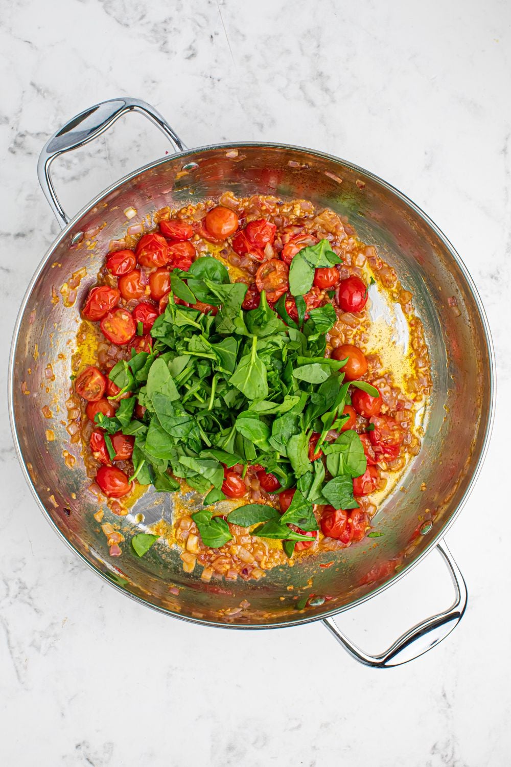 tomatoes and basil in a pan sitting on the table 