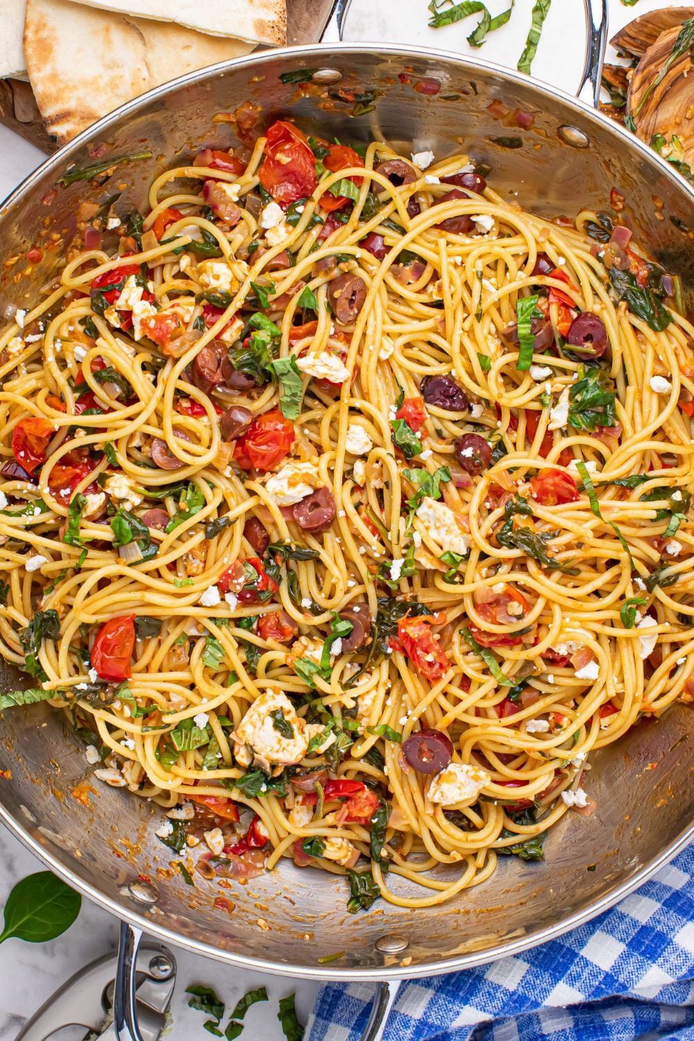 Greek Spaghetti tossed in a pan on table 