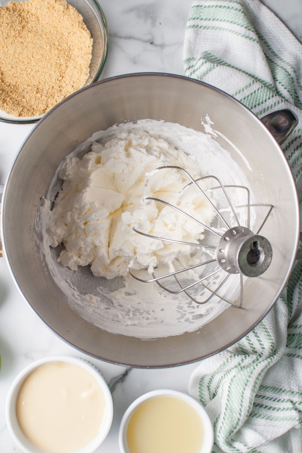 whipped cream cheese in a mixer bowl for the Crumbl Key Lime Pie Cookies