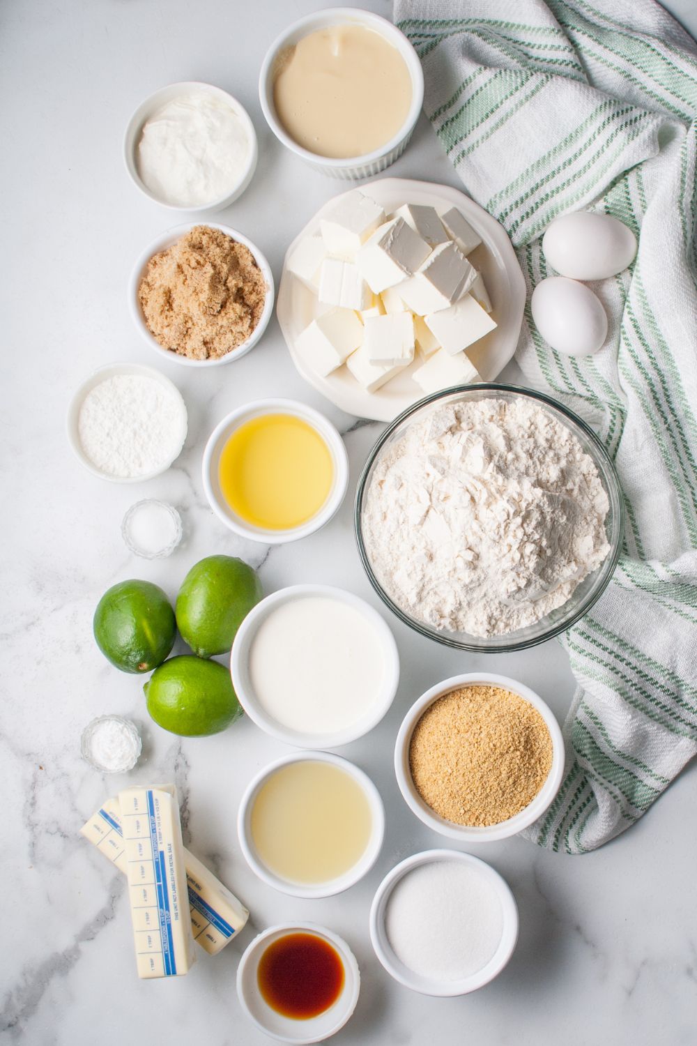 Crumbl Key Lime Pie Cookies- all the ingredients for the key lime pie cookies in single serve bowls on the table with a towel under it