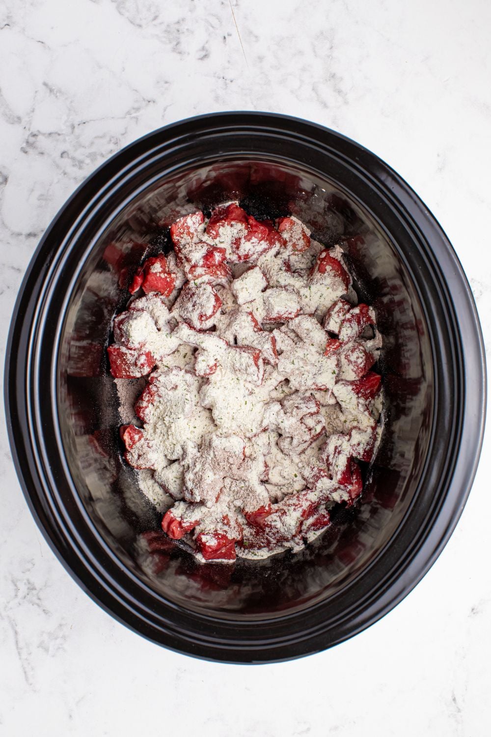 Crockpot Mississippi Steak Bites with diced steak and dry seasoning sprinkled on top of meat