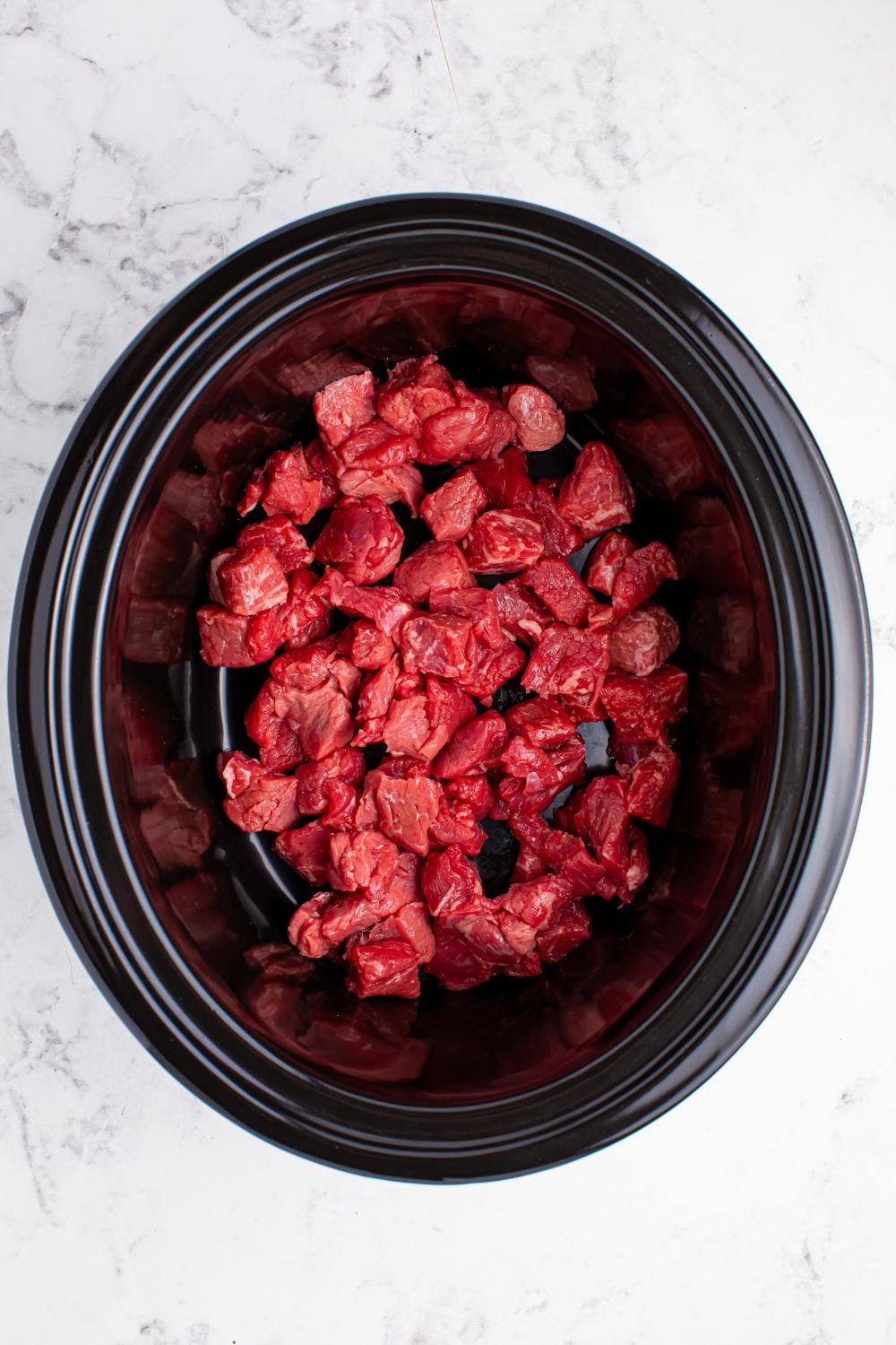 Crockpot Mississippi Steak Bites - diced steak bites in a slow cooker on the table
