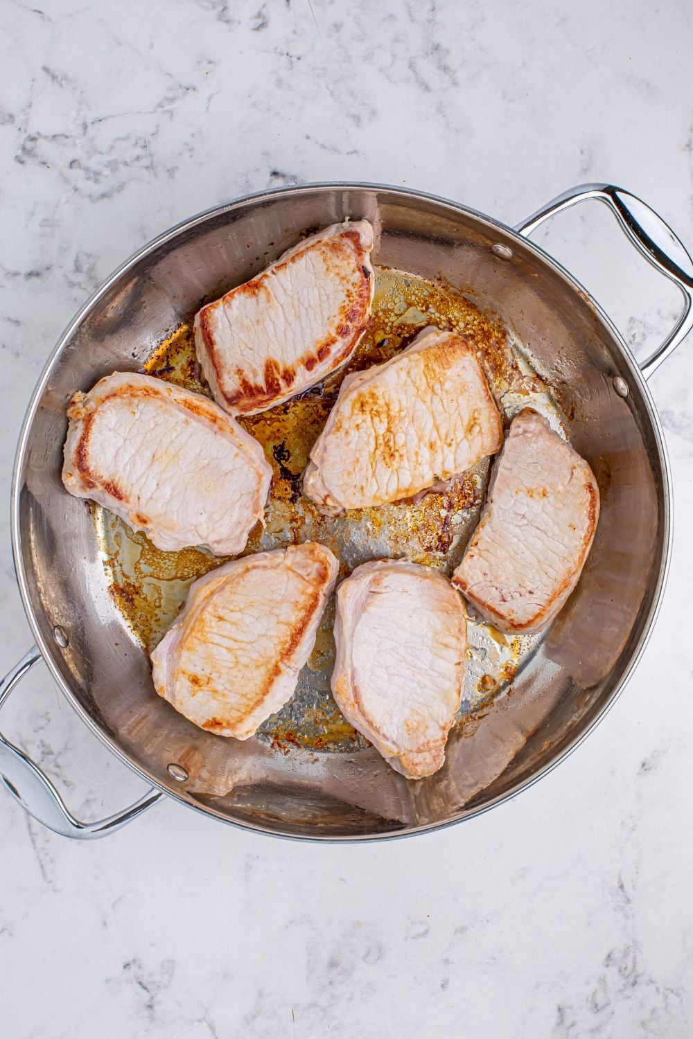 seared pork chops in a pan for making Crock Pot Mississippi Pork Chops