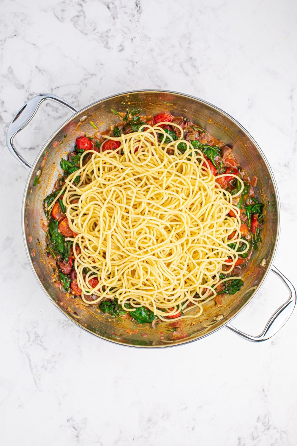 spaghetti tossed in pan for making Greek Spaghetti