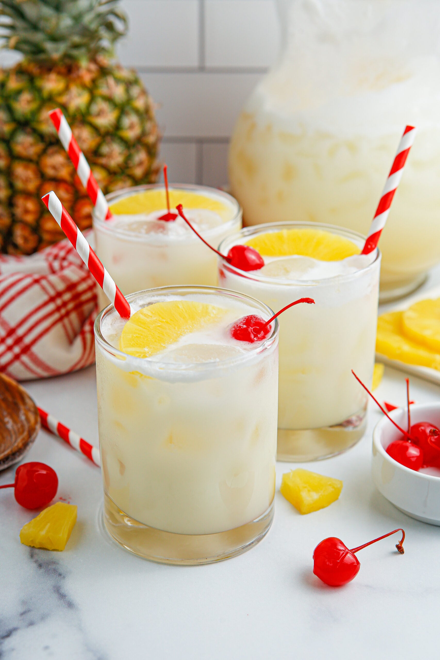 close up shots of three Pina Colada Punch in clear glasses sitting on a table 