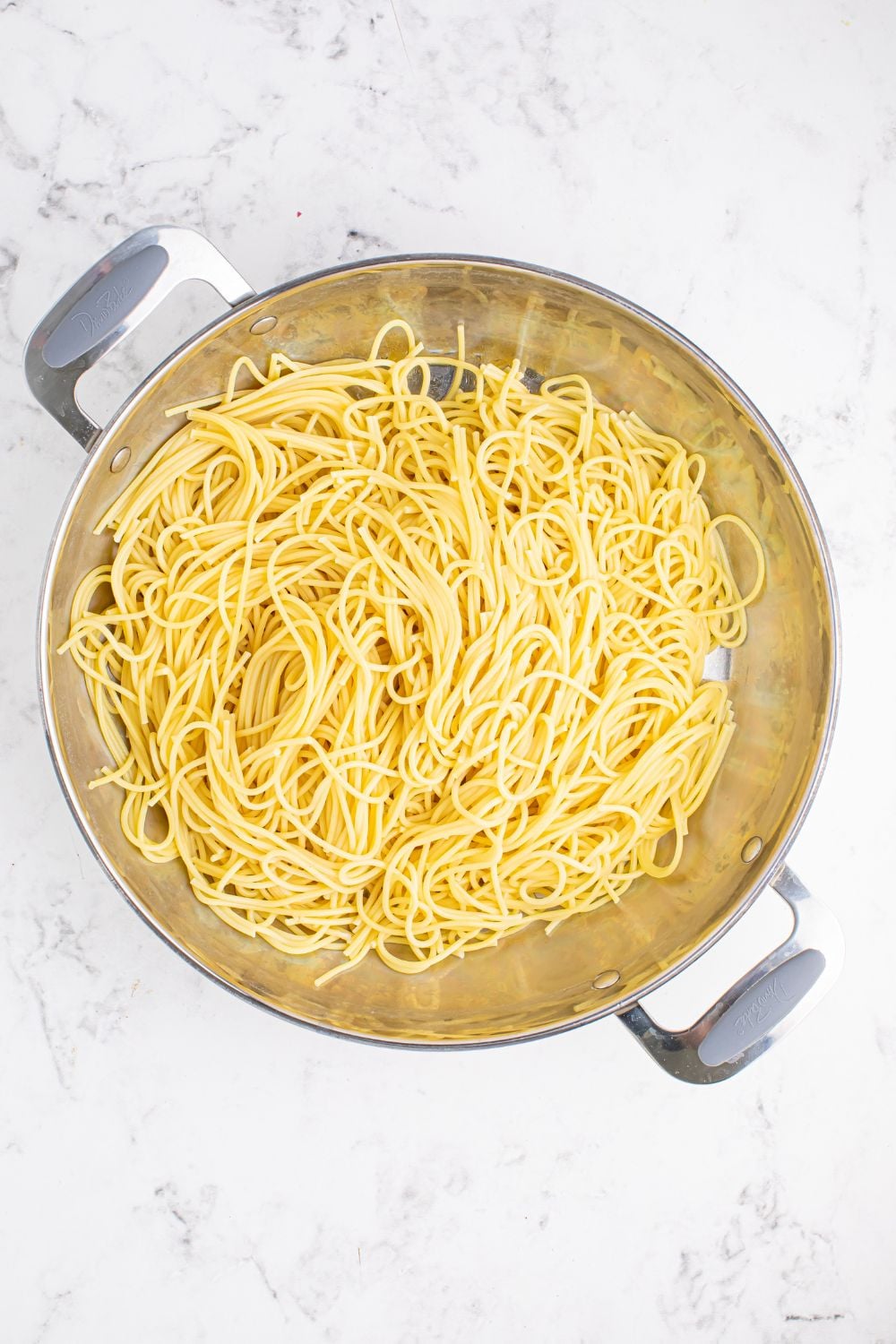 Greek Spaghetti with cooked pasta in a pan on table 