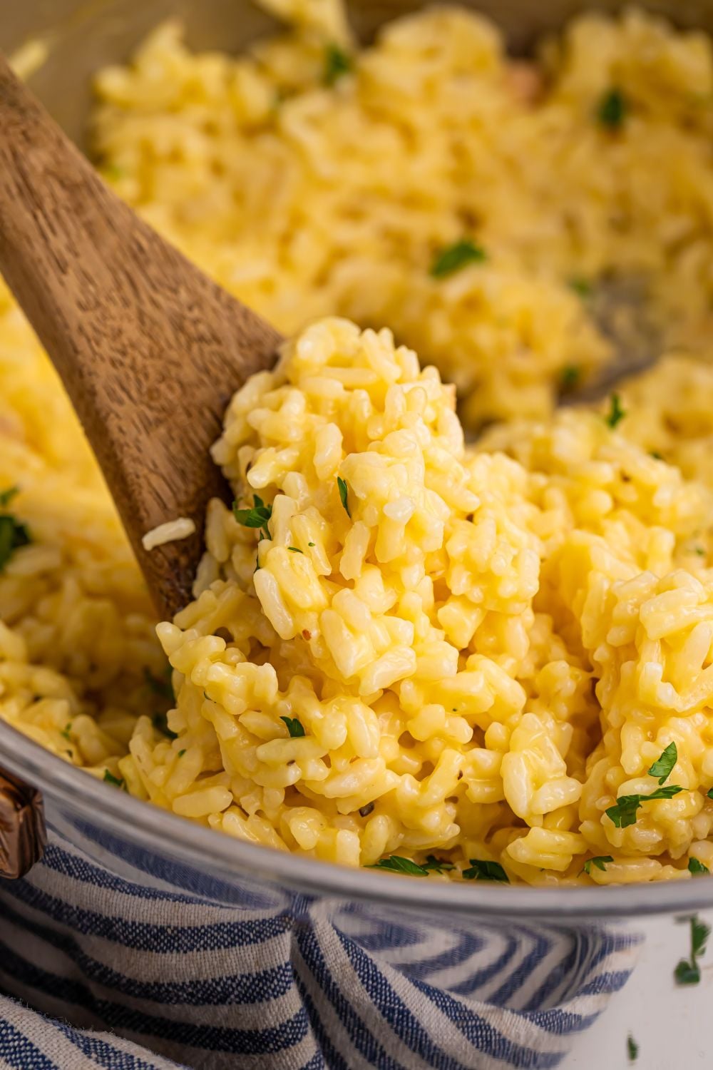 Souper Rice in a metal pan with a wooden spoon with some rice on it in pan